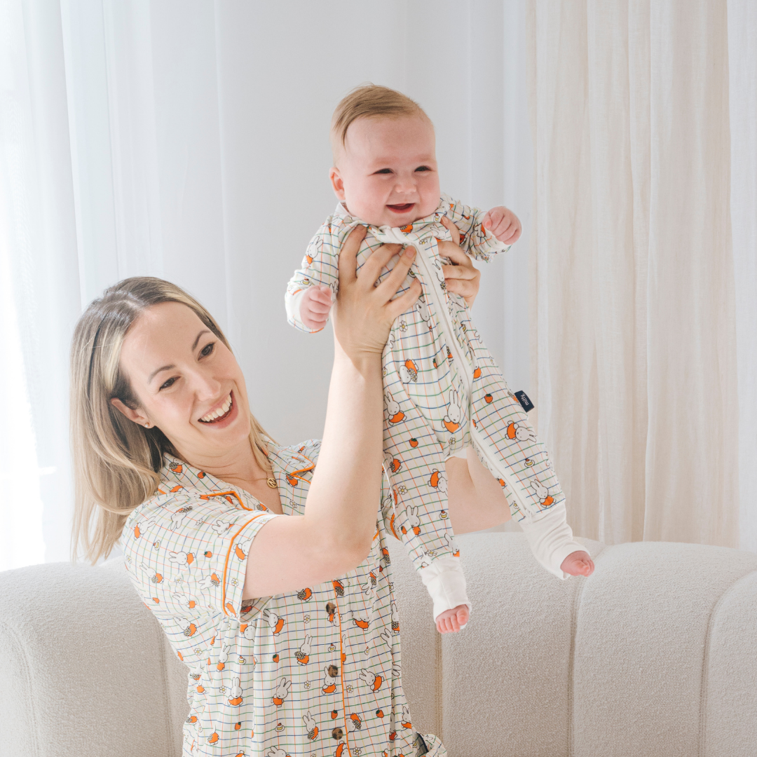 Baby klädd i en ZIPSTER x Miffy rutig Bloom-bambubodysuit