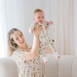 Baby klädd i en ZIPSTER x Miffy rutig Bloom-bambubodysuit