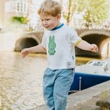 Barn iført den hvide Miffy børne-T-shirt med grøn Miffy-print