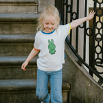 Barn iført den hvide Miffy børne-T-shirt med grøn Miffy-print