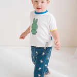 Barn iført den hvide Miffy børne-T-shirt med grøn Miffy-print