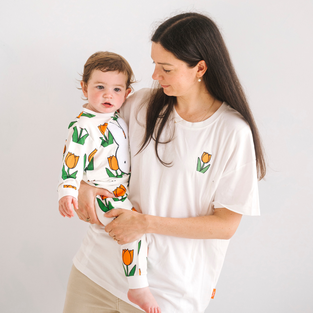Kvinde iført den Miffy hvide amme-T-shirt med broderet tulipan og ammeåbninger