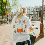 Kvinde iført den Miffy hvide amme-T-shirt med broderet tulipan og ammeåbninger