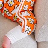 Baby wearing the ZIPSTER x Miffy Daisy Days bamboo babygrow