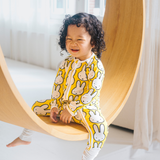 Baby klädd i ZIPSTER x Miffy Hello Yellow bambu-babyoverall